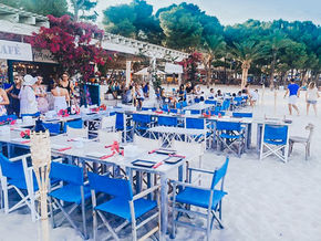blue chairs, white wooden tables, restaurant on the beach in palmanova