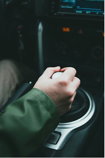 a hand on a car's gearshift