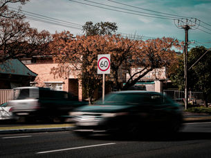 car speeding past a speed limit sign
