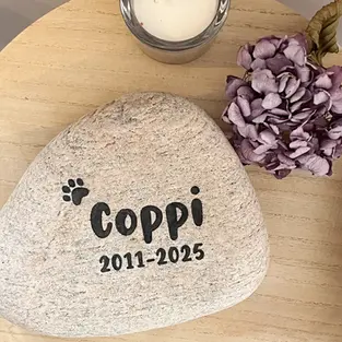 Ein runder Findling als Grabstein für dein geliebtes Haustier mit personalisierter Gravur bestehend aus Wunschtext mit Wahlschrift und Pfotenmotiv