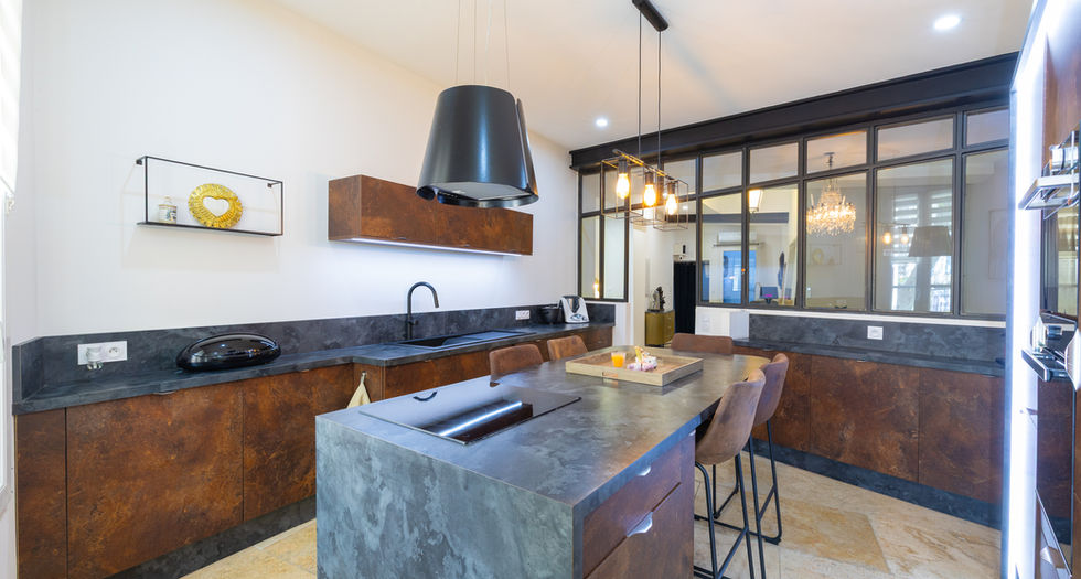Zoom cuisine moderne ilot central en pierre sombre meubles en bois et verriere noire