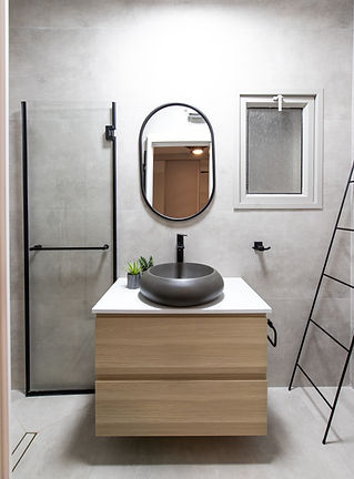 חדר רחצה ברעננה שימוש בחומריות של בטון פרזול שחור ועץ