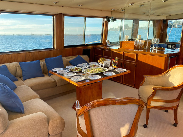 wood dining area and soft couch seating onboard yacht in La Paz