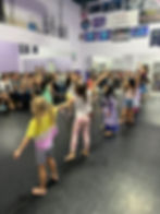 Young dancers performing for an audience in a studio.
