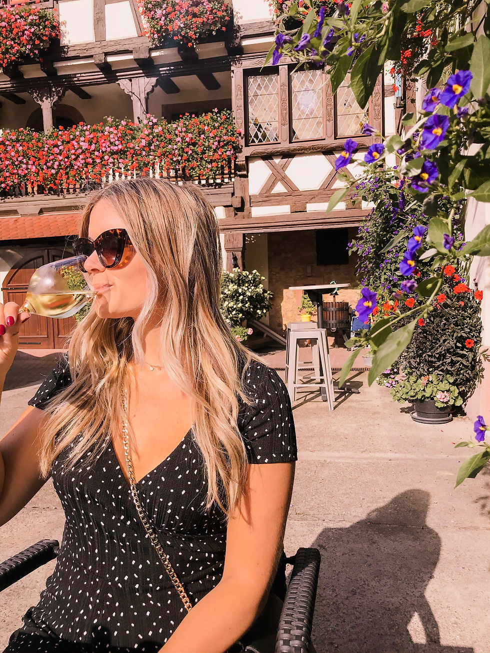 Girl drinking wine on a terrace in Eguisheim, the Alsace region of France