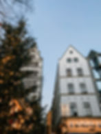 View of white buildings in Cologne beside a Christmas tree and blue sky