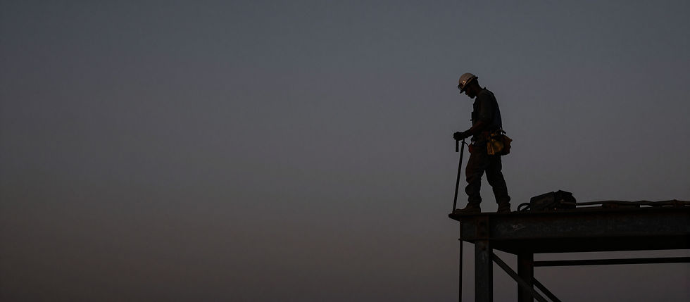 Ironworkers on a high-rise construction site at sunset