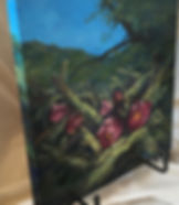 Fushia cactus blooms amid spiny stalks color this Lindy Cook Severns oil painting displayed on a table easel.