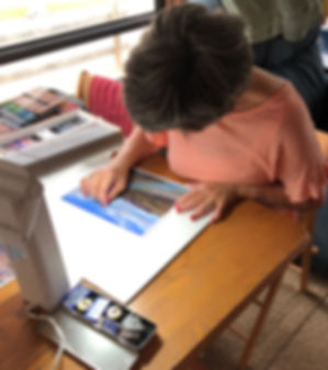Artist Lindy Cook Severns painting in pastels at the kitchen table in her RV studio space
