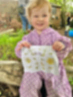 a child proudly holding her hapa zome print