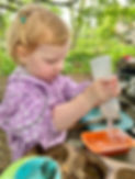 child playing in the mud kitchen