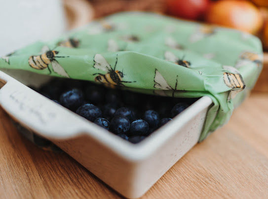 Eye-level view of beeswax wraps covering a bowl of salad