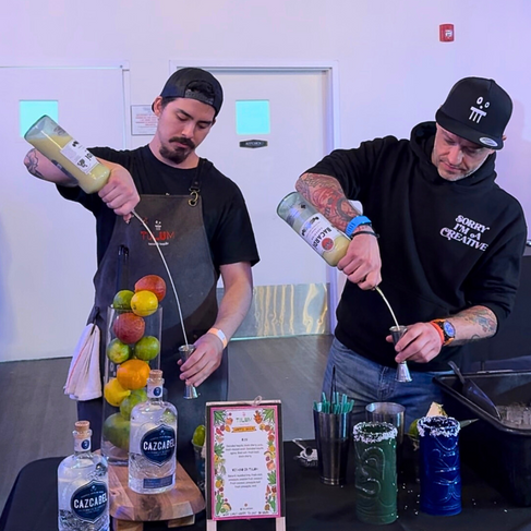 two bartenders pouring spirit
