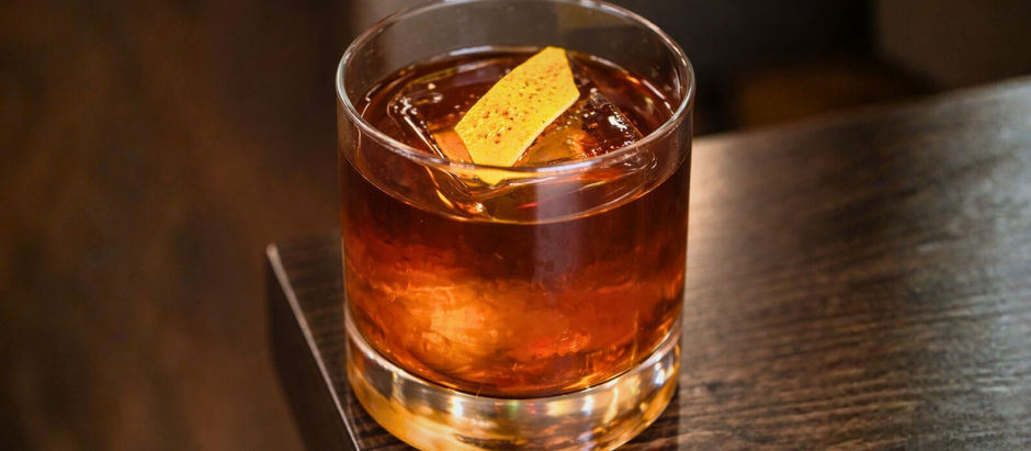 Matt Kourie’s Irish Coffee Old Fashioned cocktail with Irish whiskey, coffee liqueur, and flamed lemon peel on a large ice cube, a stirred espresso martini alternative perfect for St. Patrick’s Day