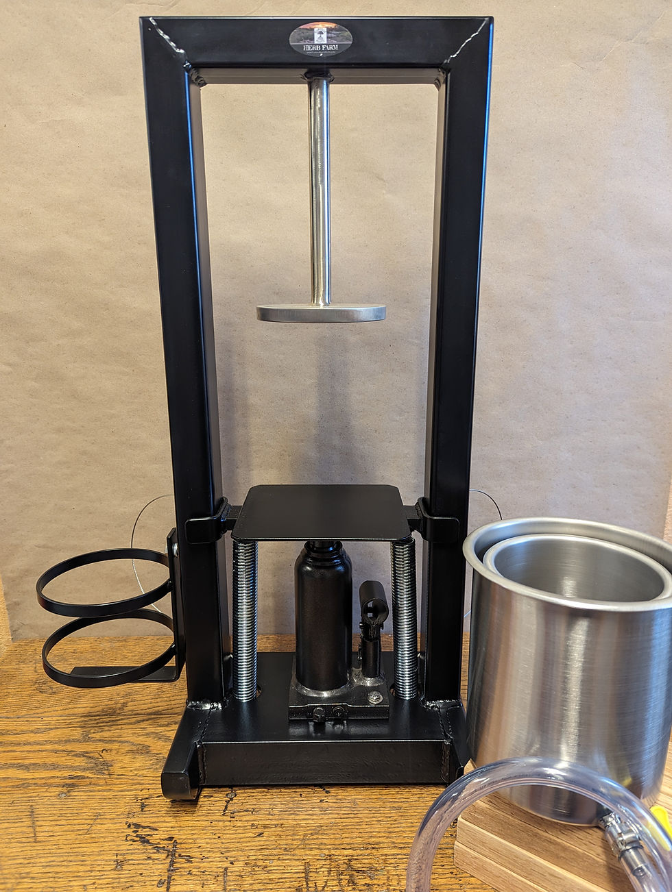 Thumbnail: Black metal press machine with stainless steel container for processing.