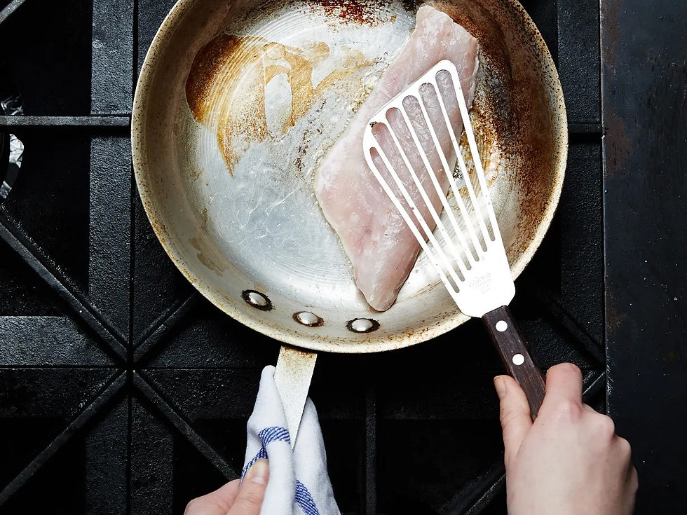 Cooking fish in a stainless steel skillet with a Winco fish spatula