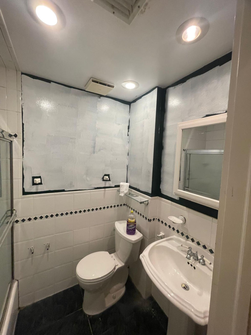 Small bathroom with toilet, sink, and mirror.