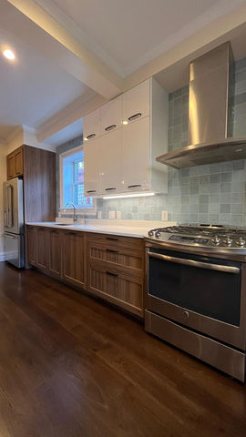 Modern kitchen with wooden cabinets and stainless steel appliances.