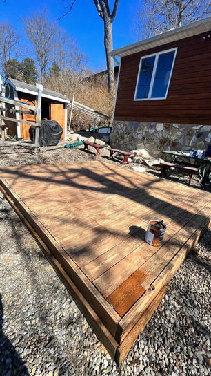 Wooden deck under construction in outdoor setting.