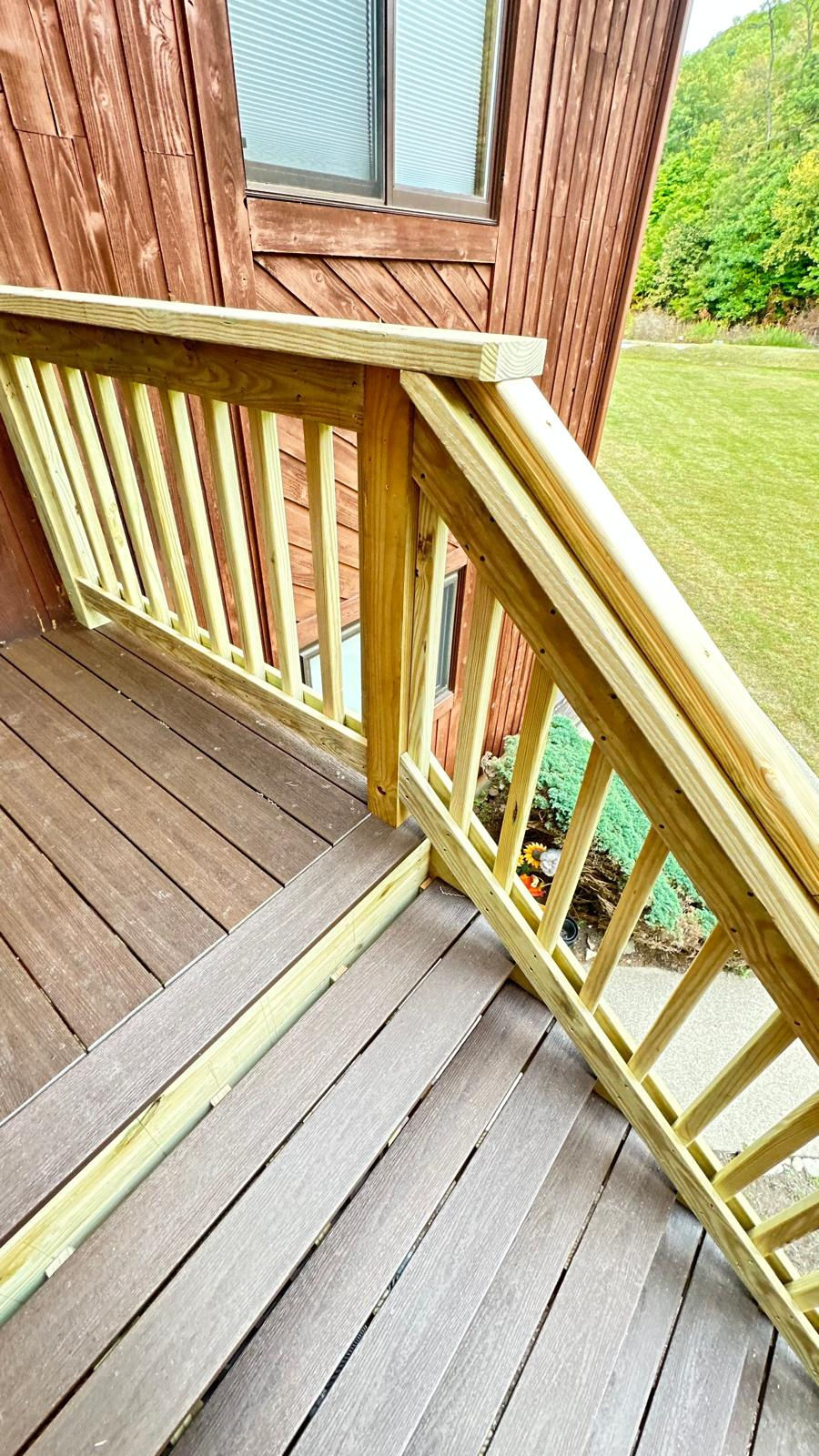 Wooden deck stairs with railing, outdoor setting.