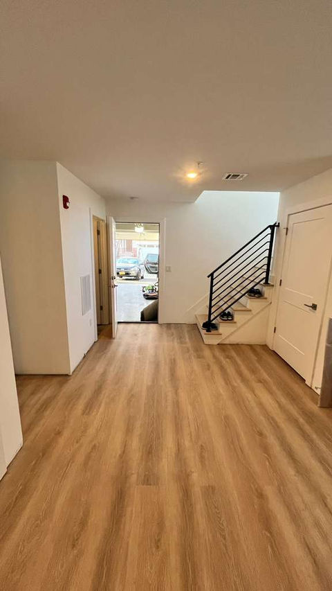 Open room with wooden floor and staircase.