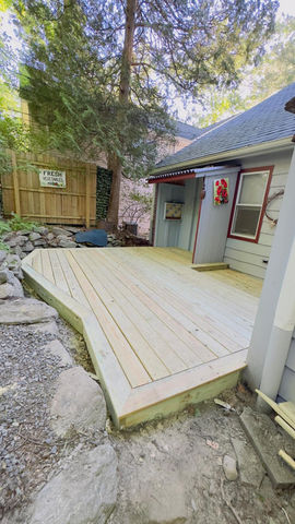 Wooden deck beside a house with a small garden.