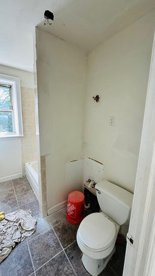 Bathroom under renovation with exposed walls and floor.
