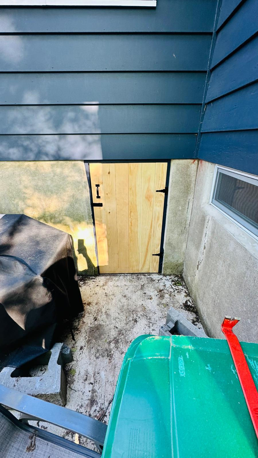 Wooden door with concrete walls and outdoor equipment.