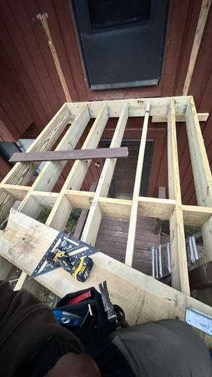Wooden deck construction with tools and materials visible.