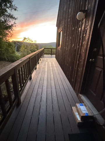 Wooden deck with sunset view and package by door.