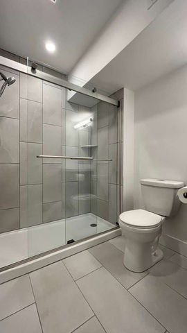 Modern bathroom with glass shower and white toilet.