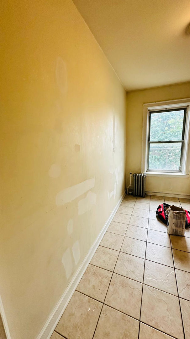 Room with tiled floor and a window.