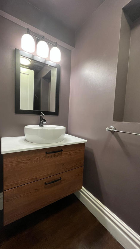 Modern bathroom with round sink and wooden vanity.