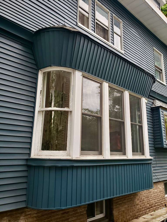 Blue house with a white-framed bay window.