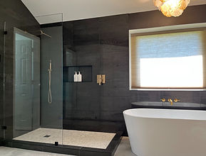Luxury bathroom remodel with black tile shower and freestanding bathtub