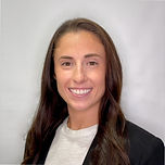 Nicki Griffith, headshot white woman with dark brown hair wearing a white shirt and a black blazer