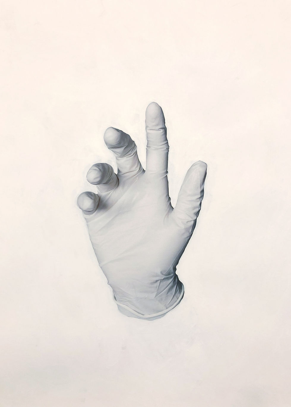 Photograph of a hand in a white latex glove, the background has been painted white.