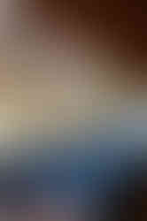 A dimly lit restaurant with open kitchen and bar seating