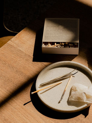 A warm table scene with burning incense and sage