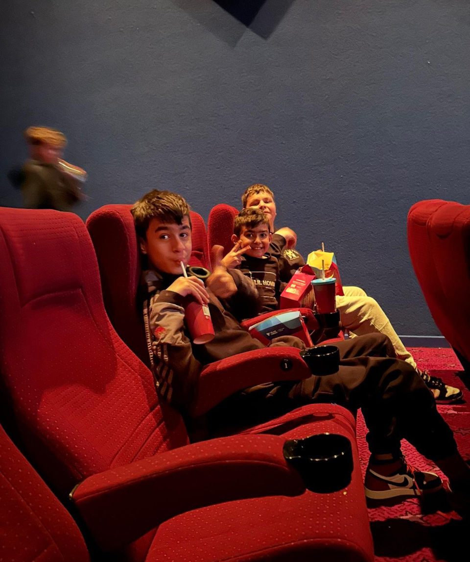 Three people in red movie theater seats