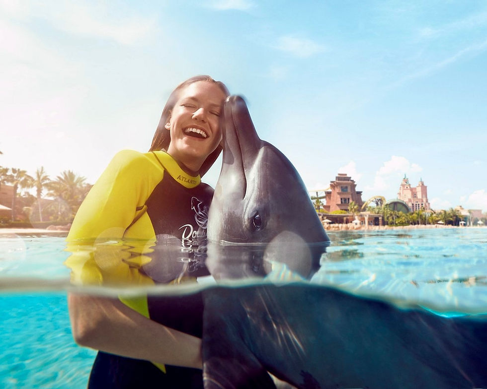 Atlantis Dolphin Bay – guest receiving a dolphin kiss during swim experience in Dubai