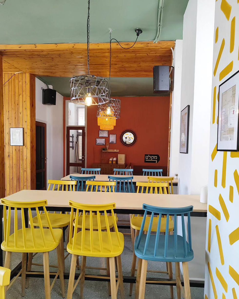 מבט מהבר אל אזור ה"סלון". שולחנות בר גבוהים וחיפוי העץ המקורי שנשמר גם הוא.