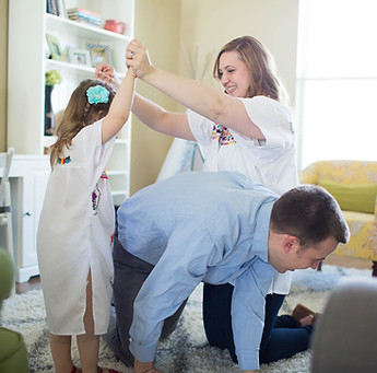 mom and dad play a game with their little girl in the living room of their South Jordan, utah home
