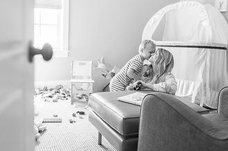 mom and preschooler share a kiss while playing in the nursery of their South Jordan, utah home