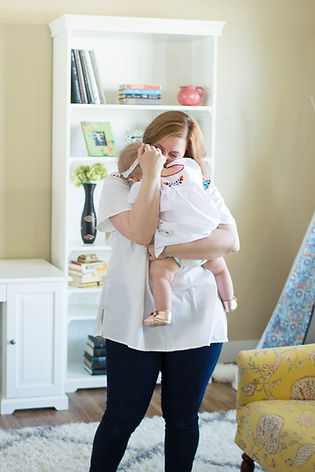 mom snuggles her baby in the living room of their South Jordan, Utah home