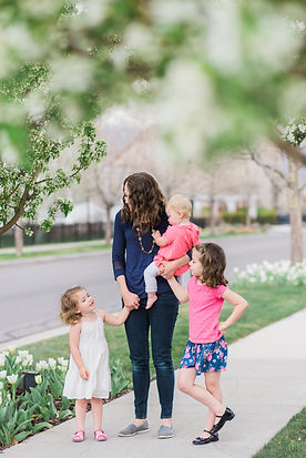 mom and her young daughters go for a spring walk in South Jordan, Utah