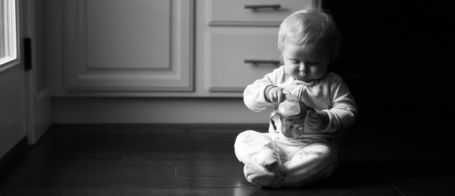 Young baby sits on the kitchen floor of their Salt Lake City, utah family home