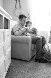 Dad reads to his little girl sitting on his lap in their South Jordan Utah home