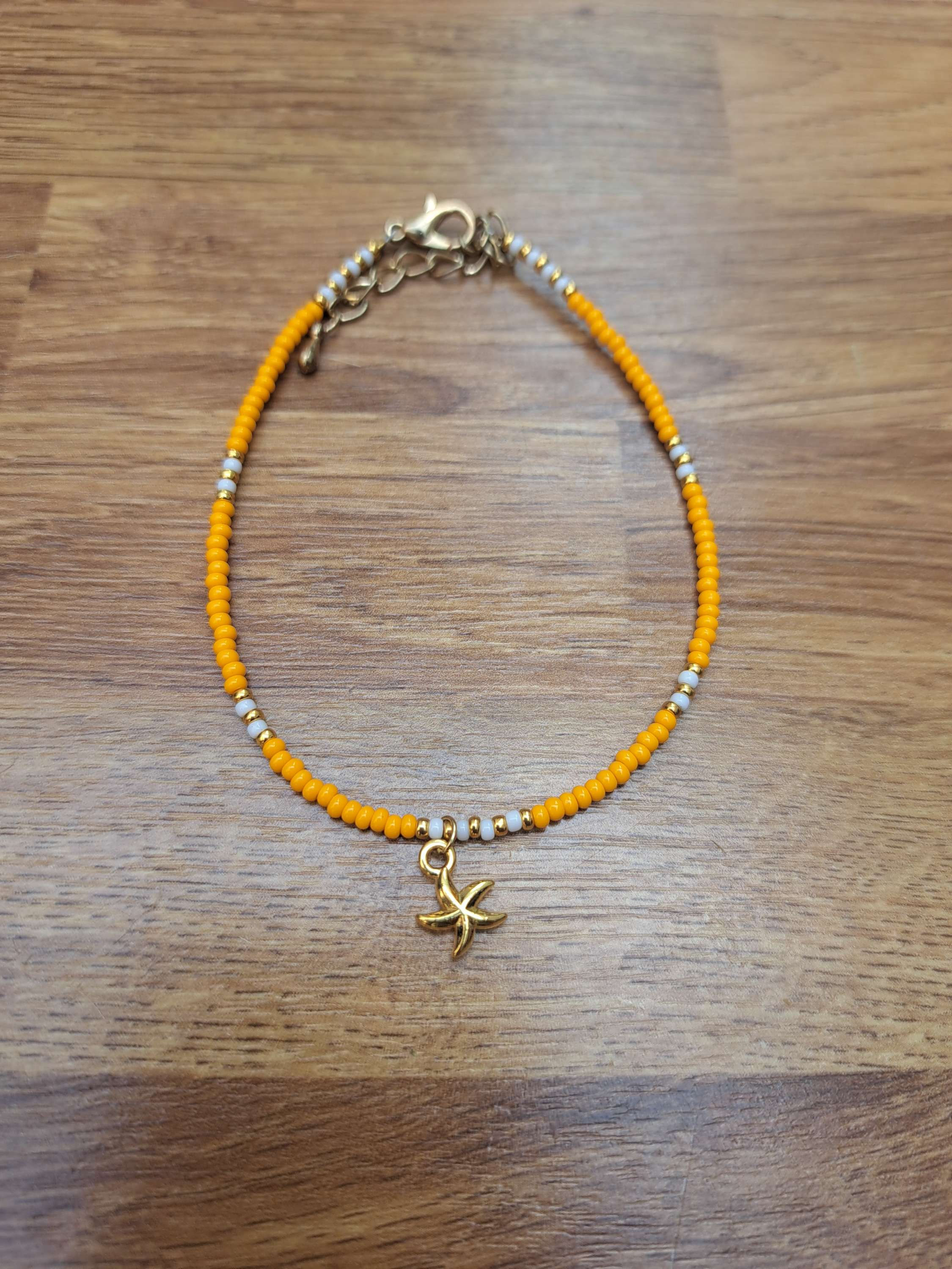 Oranje enkelbandje met zeesterretje