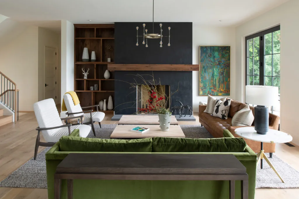 A living room centered around a black fireplace. The colors are warm with clean lines